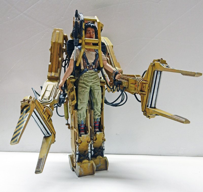 Maquette du Powerloader jaune d'Aliens avec figurine de Ripley installée aux commandes, vue de face