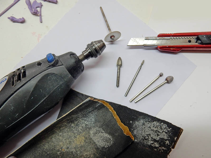 Outils pour préparer pièces en résine : mini-perceuse, fraises, disque, cutter et papier abrasif