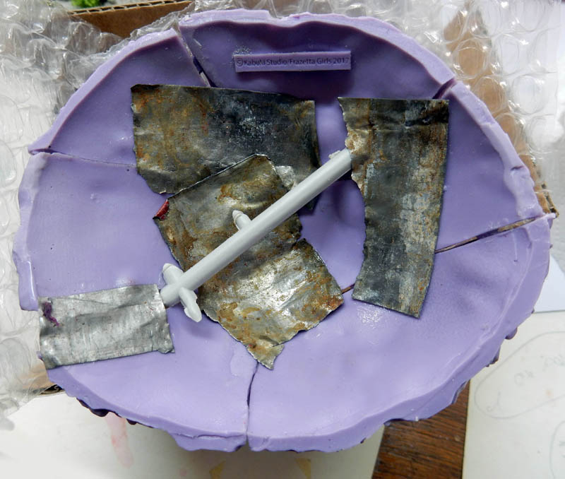 Moule en silicone violet contenant des pièces en résine grise sur film à bulles