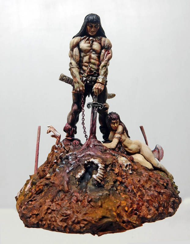 Figurine en résine peinte d'un guerrier barbare à l'épée sur un tertre rocheux