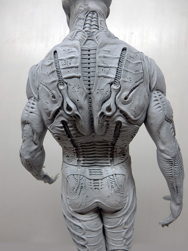 Vue de dos d'une figurine Prometheus non peinte montrant les détails biomécaniques sculptés du dos