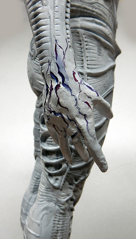 Détail de la main et du bras gris d'une figurine Prometheus avec veinures peintes en bleu