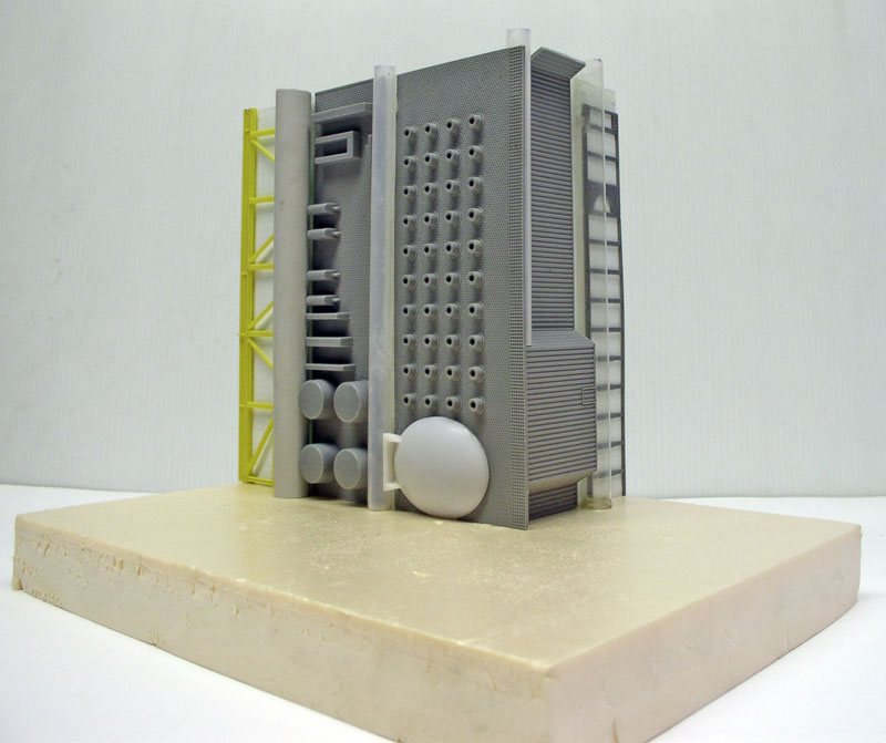 Maquette grise de structure industrielle détaillée avec échafaudage jaune sur socle beige