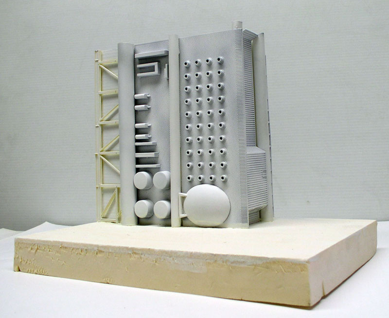 Maquette grise en cours de montage façade industrielle détaillée posée sur socle en mousse