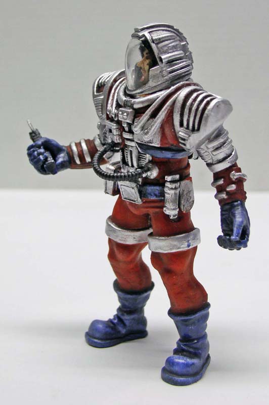 Figurine peinte d'astronaute rétro en combinaison rouge et argent avec casque