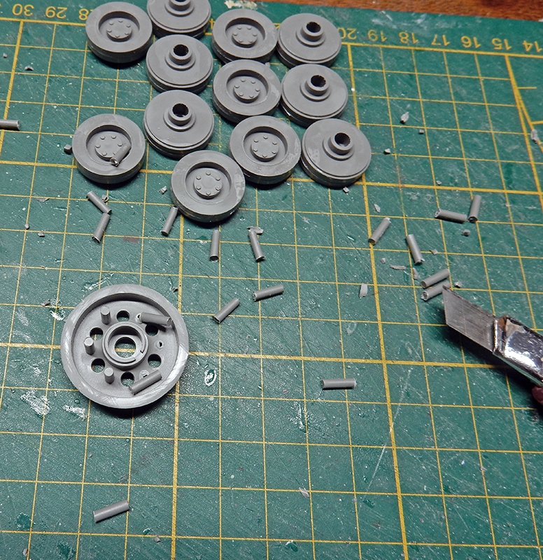 Galets de roulement gris du Panzer III en cours d'assemblage sur tapis de découpe