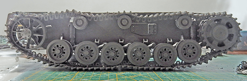 Vue latérale du châssis de Panzer III avec chenilles, galets et barbotin assemblés et peints en gris