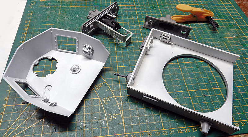 Pièces de tourelle gris clair du Panzer III en cours d'assemblage sur tapis de découpe