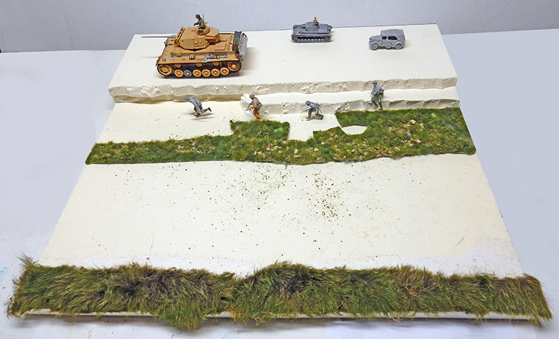 Maquette de diorama avec Panzer III, véhicules et figurines sur un terrain en polystyrène végétalisé