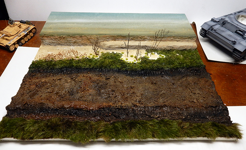 Diorama de maquette représentant un terrain boueux avec végétation et arbres morts, maquettes de Panzer III à côté