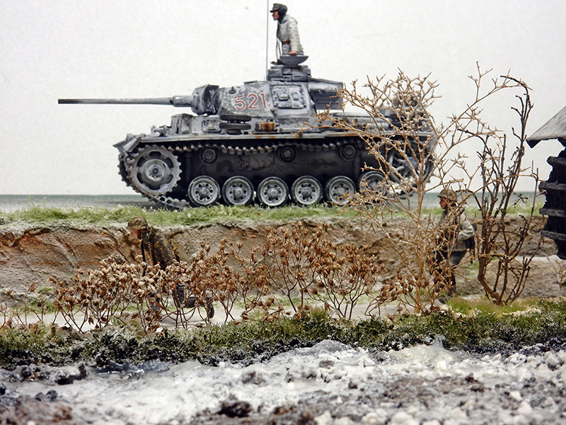 Maquette de Panzer III numéro 521 dans un diorama hivernal avec végétation sèche et talus