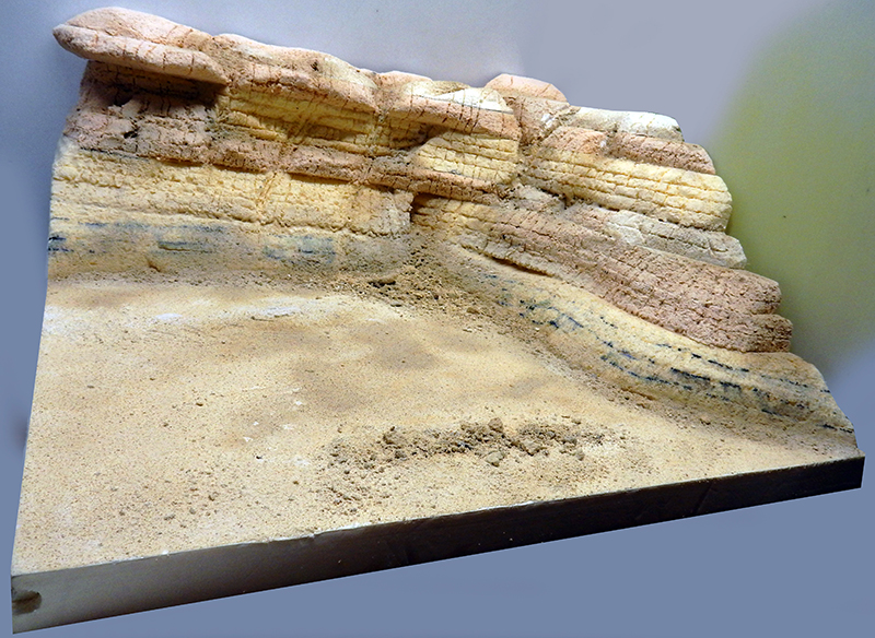 Diorama de paysage désertique avec falaise rocheuse stratifiée et sol sablonneux pour maquette