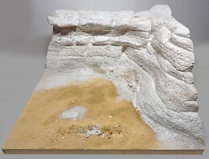 Décor de diorama en plâtre représentant une falaise rocheuse blanche surplombant un sol sableux