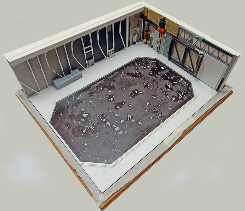 Maquette d'un hangar industriel avec bassin octogonal central, murs détaillés et structures métalliques sur socle bois
