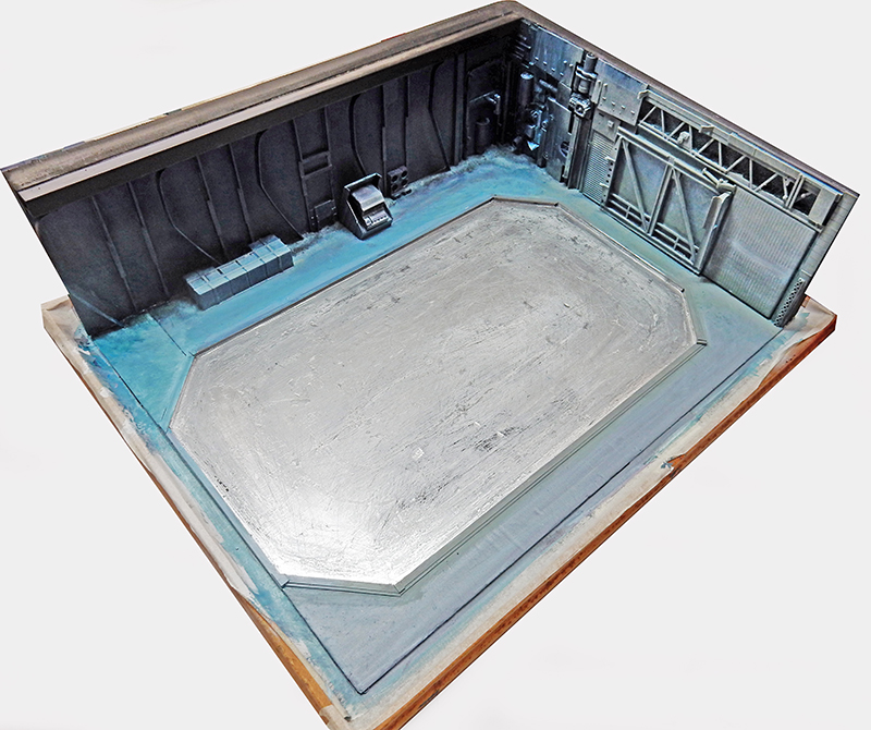 Maquette de décor de hangar industriel science-fiction avec sol gris et murs sombres détaillés