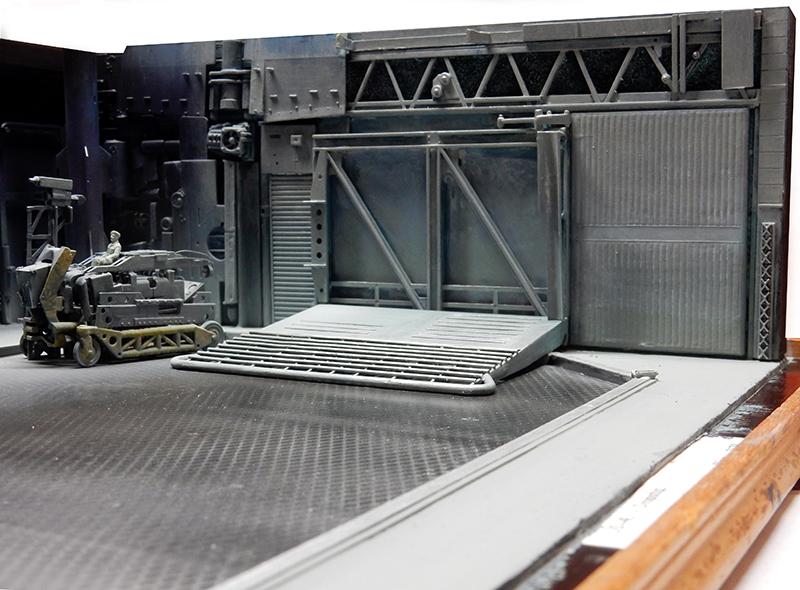 Diorama de hangar industriel science-fiction avec chariot élévateur et grande porte métallique à structure