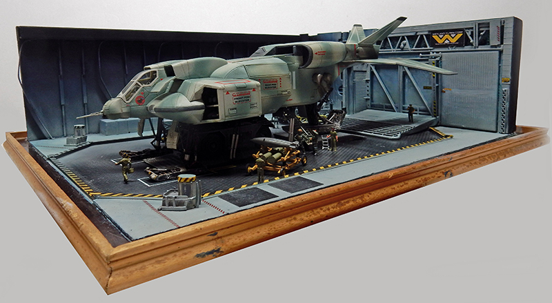 Diorama de maquette représentant un vaisseau militaire dans un hangar avec figurines et caisses