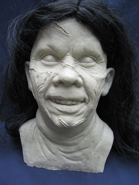 Buste sculpté du visage de Regan possédée, cicatrices et cheveux noirs, fond bleu