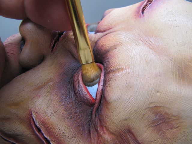 Mise en peinture au pinceau de l'œil sur le visage marqué de Regan