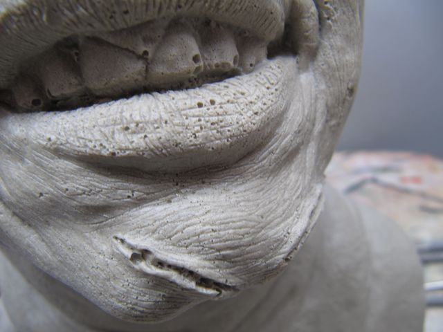 Gros plan sur la bouche et le menton sculptés du buste de Regan, texture de peau ridée non peinte