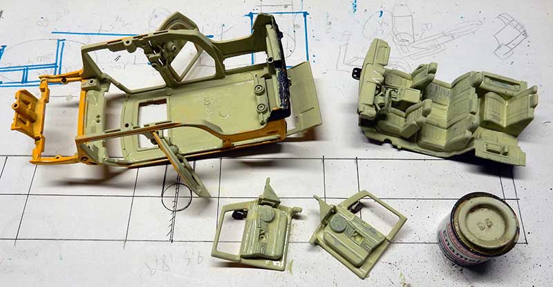 Pièces de carrosserie de maquette de véhicule en plastique vert posées sur un plan technique