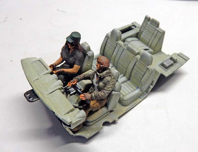 Maquette d'intérieur de véhicule avec deux figurines peintes assises sur les sièges
