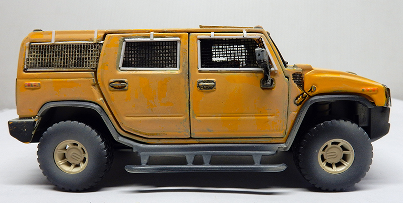 Maquette de Hummer H2 jaune vieilli avec grilles aux fenêtres, vue de profil