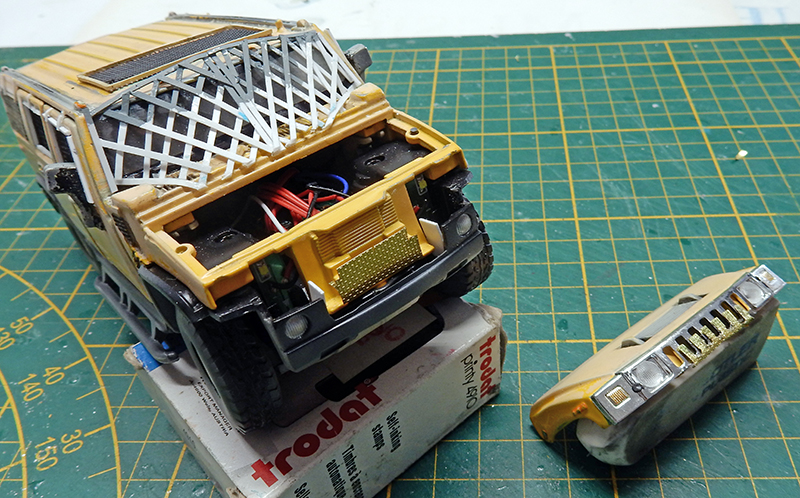 Maquette de Hummer jaune en cours de montage avec capot ouvert et calandre détaillée