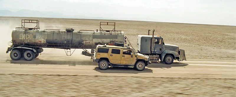 Camion-citerne et Hummer jaune roulant dans le désert poussiéreux du convoi Resident Evil Extinction