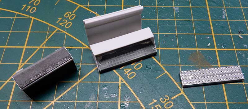 Pièces de maquette en plastique avec plaque rivetée en cours de fabrication sur tapis de découpe
