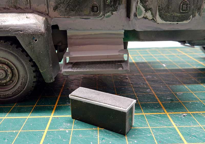 Marchepied en plasticarte sous la maquette de véhicule militaire posée sur tapis de découpe