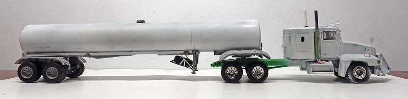 Maquette de camion semi-remorque citerne argenté vu de profil sur fond gris
