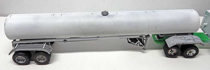 Maquette de camion-citerne gris attelé à une remorque verte, vue de côté