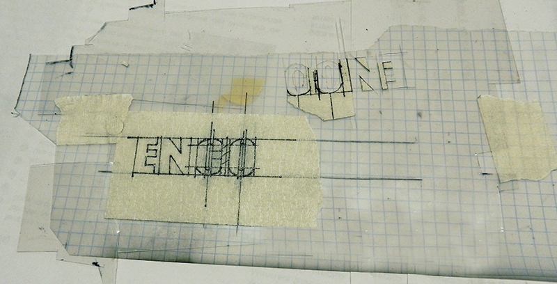 Gabarit en papier calque quadrillé avec lettres tracées au crayon et ruban adhésif
