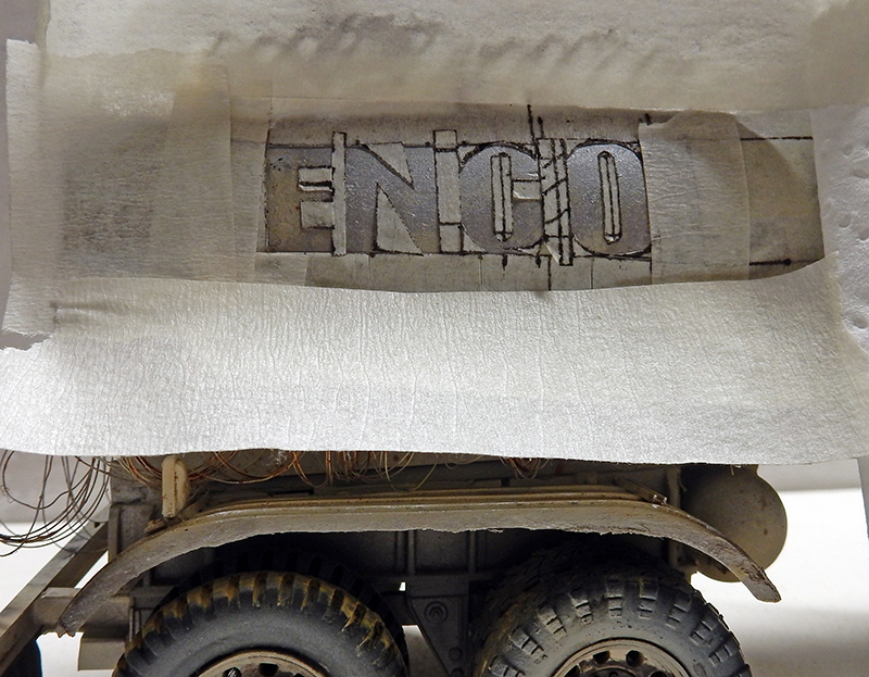 Pochoir du lettrage ENGO peint au stencil sur la maquette de camion avec masquage