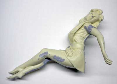 Figurine de femme allongée en cours de montage avec mastic appliqué avant ponçage