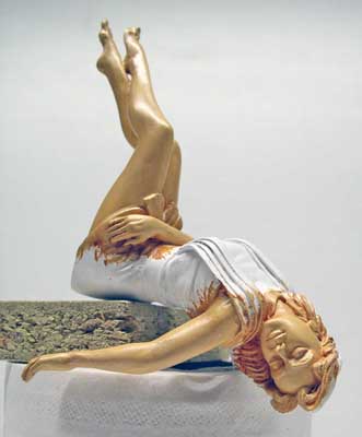 Figurine peinte d'une jeune femme évanouie renversée en arrière sur un socle rocheux