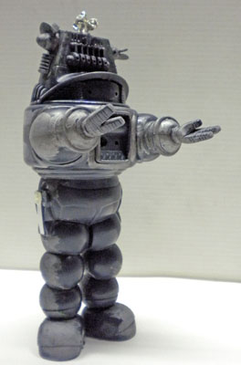 Maquette de Robby le robot peinte en gris métallisé, bras tendu, vue de profil