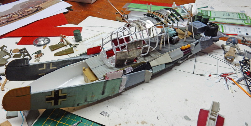 Maquette de bateau militaire en construction sur établi avec pièces et outils de modélisme