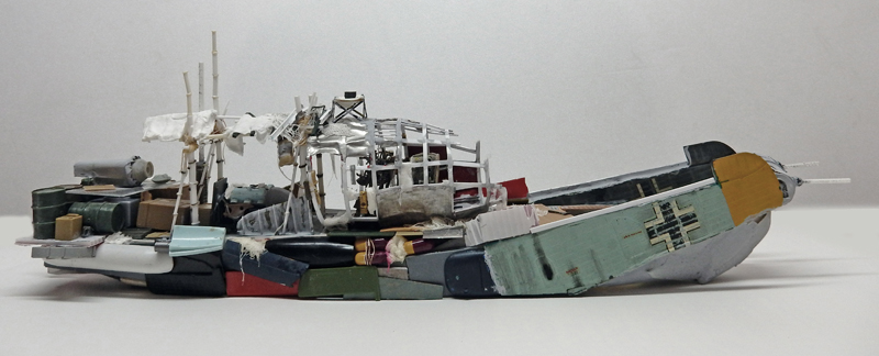 Maquette de bateau échoué fait d'épaves d'avions et débris assemblés, vue latérale