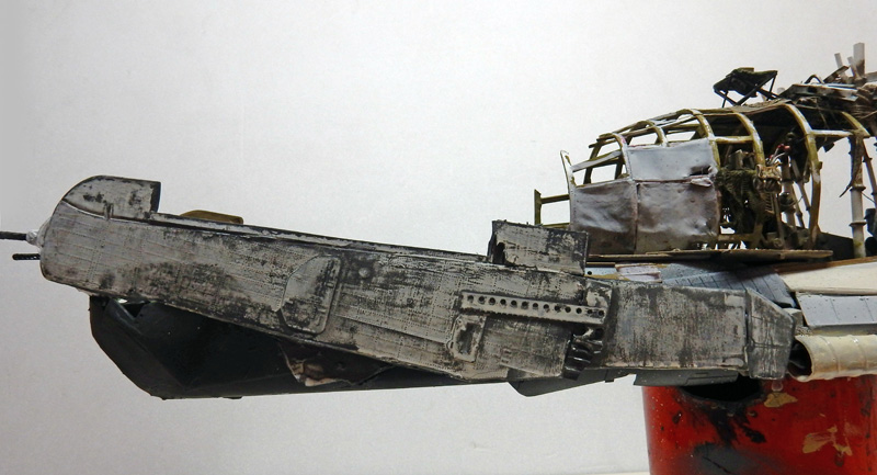 Maquette d'épave d'avion vieillie avec fuselage gris patiné et structure arrière squelettique apparente