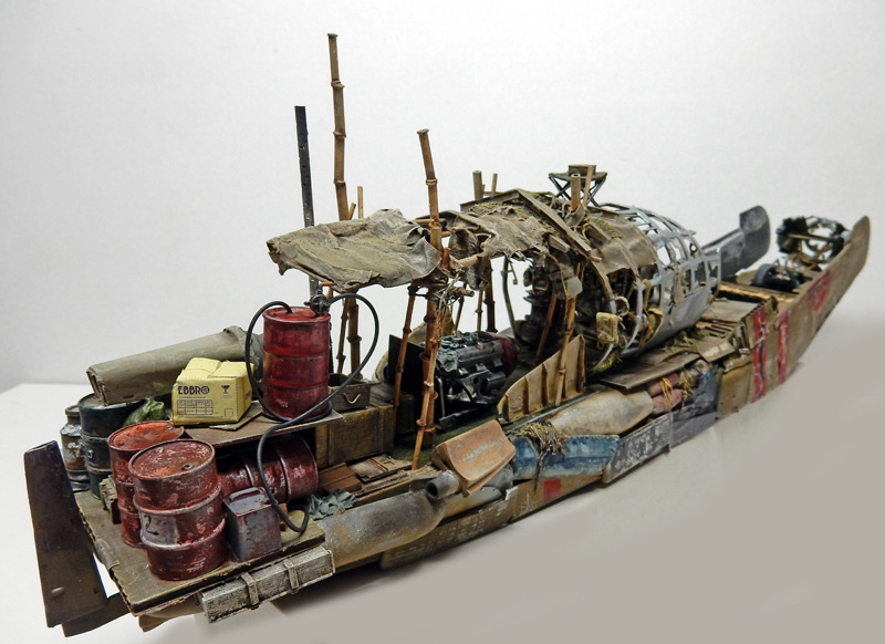 Maquette de bateau de récupération vieilli chargé de bidons rouillés, bambous et débris divers