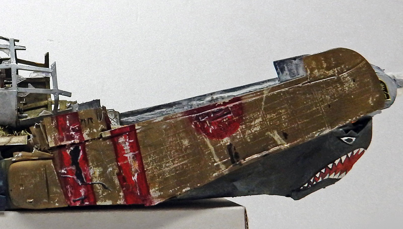 Coque de bateau en bois patinée avec gueule de requin peinte, bandes rouges usées