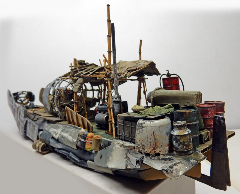 Maquette de bateau de pêche vieilli encombré de barils rouillés, bâches et mâts de bambou
