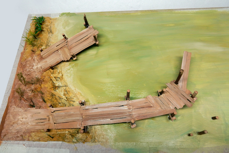 Pontons en bois sur pilotis longeant la rive d'un lagon vert sur la maquette