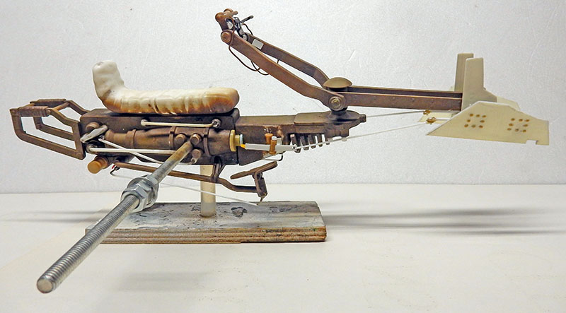 Maquette de speedbike en cours de montage sur socle provisoire, structure métallique vieillie visible