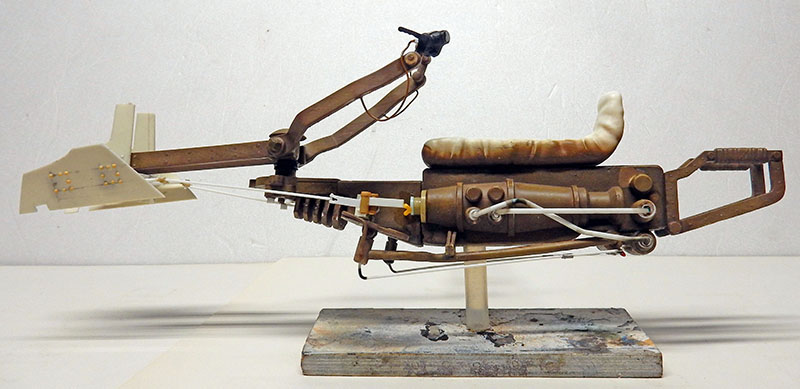Maquette de speedbike ocre en cours de montage, vue de profil sur socle