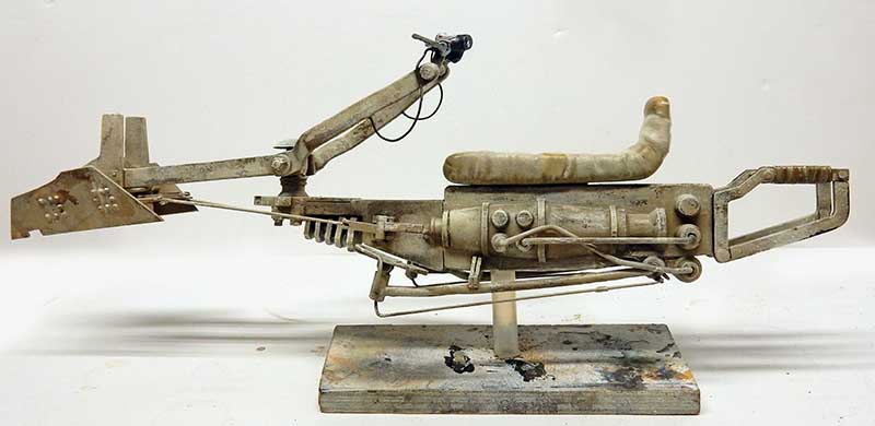 Maquette de speedbike volant vue de profil sur socle, finition patinée ocre