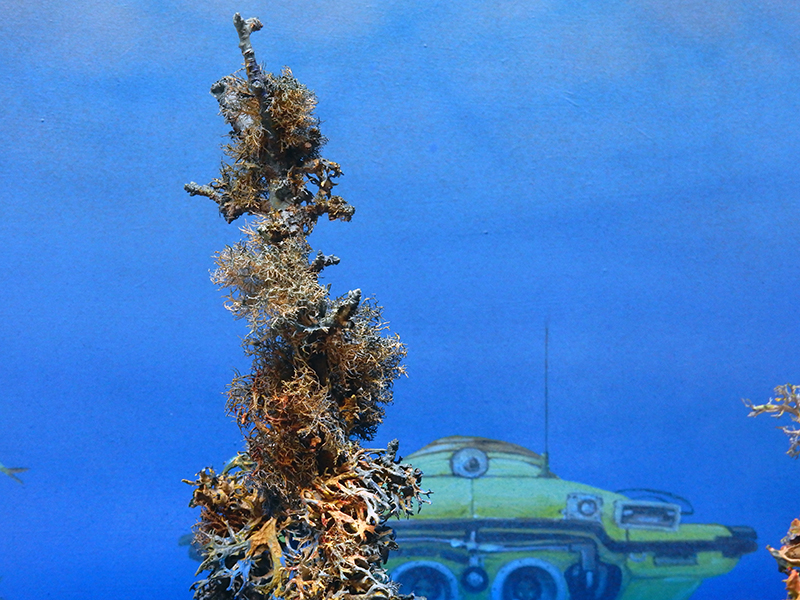 Diorama sous-marin avec végétation corallienne et sous-marin jaune et vert sur fond bleu