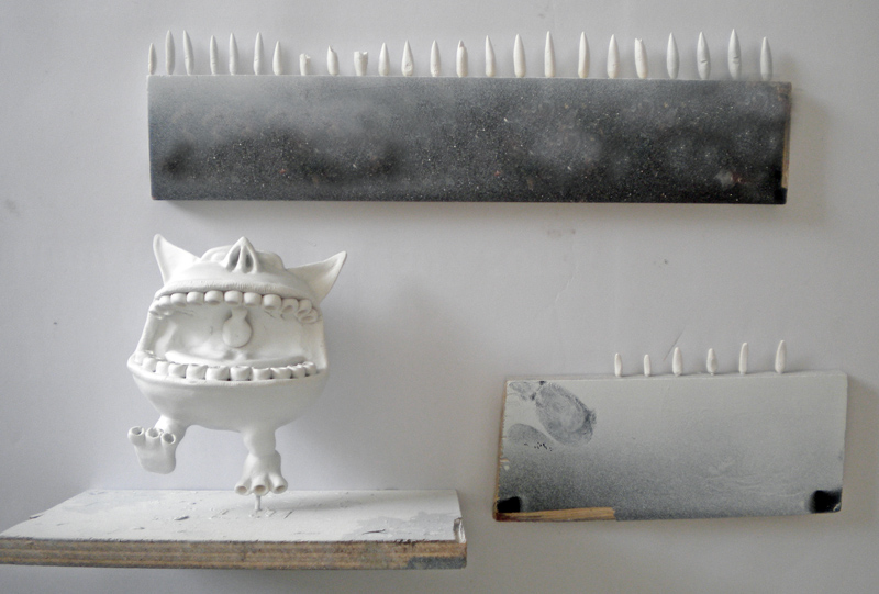 Squig blanc sculpté en cours de séchage près de planches hérissées de dents pointues